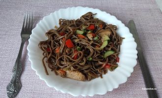 Гречневая лапша с курицей и овощами на тарелке