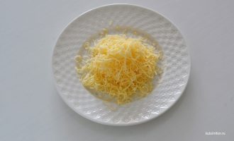 Сыр тертый на тарелке