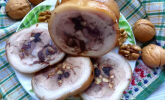 Рулет из свиной рульки вареный с черносливом и орехами на тарелке