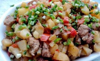 Готовое блюдо картофель со свининой и болгарским перцем на тарелке