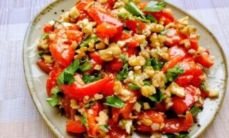 Закуска из запеченного болгарского перца с грецким орехом и зеленью на тарелке