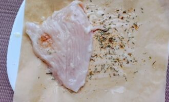 Куриная отбивная выложена на пергамент со специями