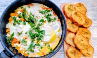 Готовая яичница с брынзой, зеленью и чесночными гренками